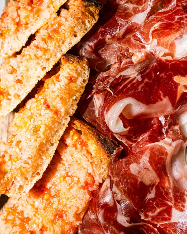 Un dels nostres imprescindibles: espatlla de pernil ibèric de gla 100% acompanyada de pa de vidre. Senzillesa i qualitat ideal per a combinar amb un bon vii.

Uno de nuestros imprescindibles: espaldilla de jamón ibérico de bellota 100%, acompañada de pan de cristal. Sencillez y calidad, ideal para combinar con un buen vino.

One of our must-haves: 100% acorn-fed Iberian ham shoulder, accompanied by glass bread. Simplicity and quality, perfect to pair with a good wine.